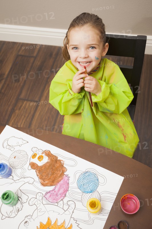 Caucasian girl painting at table