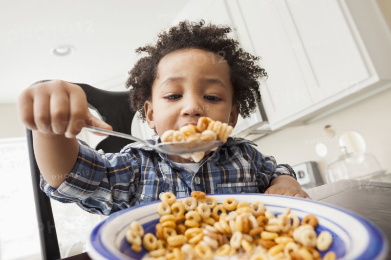 Mixed race boy eating at table