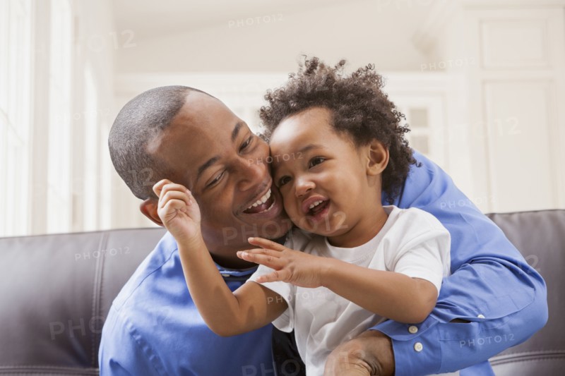 Father and son relaxing on sofa