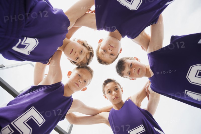 Caucasian basketball team in huddle