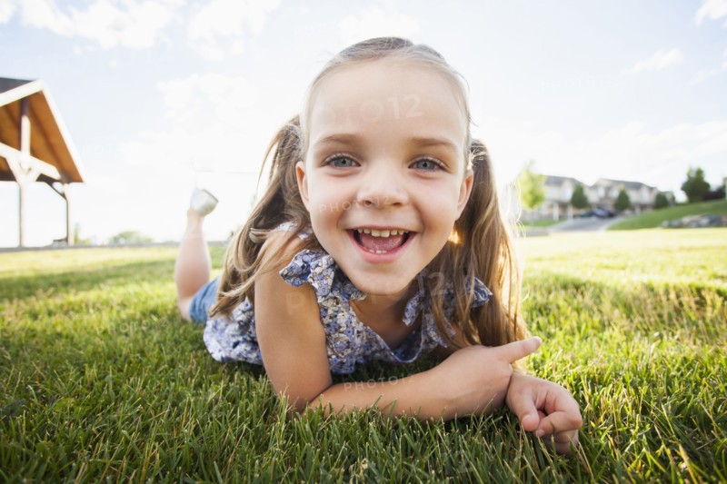Caucasian girl laying in grass