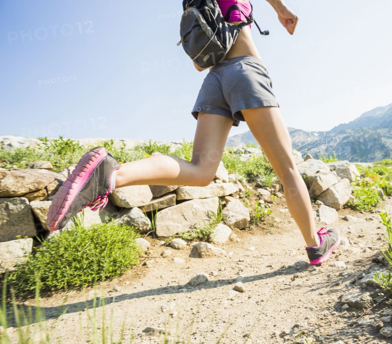 Caucasian woman running on rocky trail