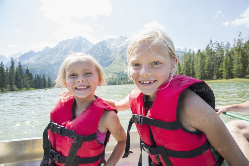 Caucasian girls wearing life jackets in canoe