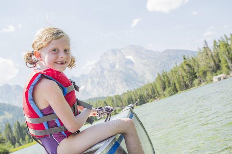 Caucasian girl sitting in canoe on lake