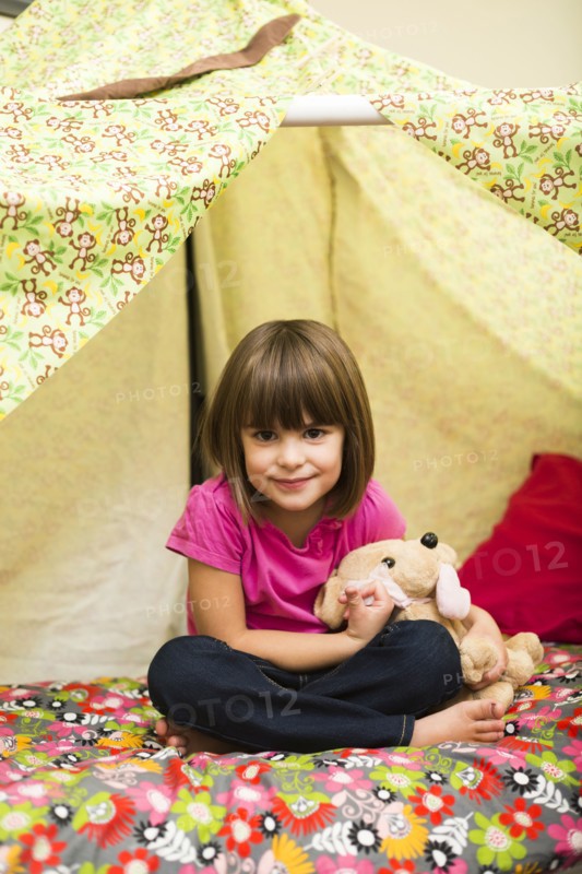 Caucasian girl sitting in blanket fort