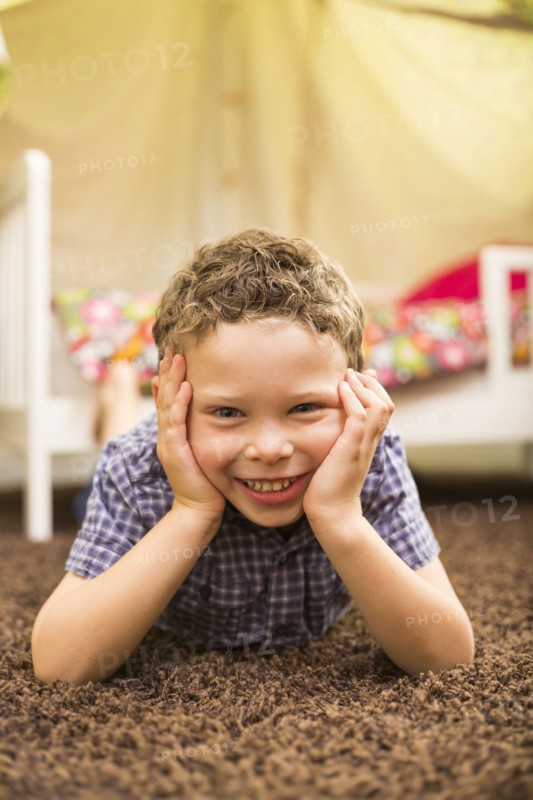 Caucasian boy smiling in bedroom