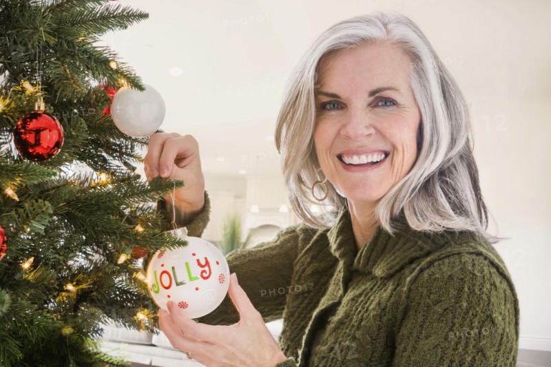 Portrait of Caucasian woman hanging ornaments on Christmas tree
