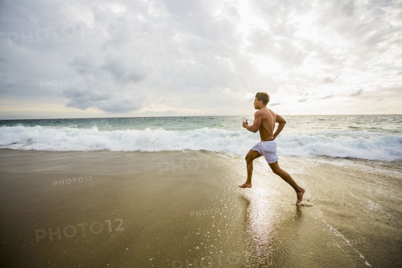Caucasian man running on beach