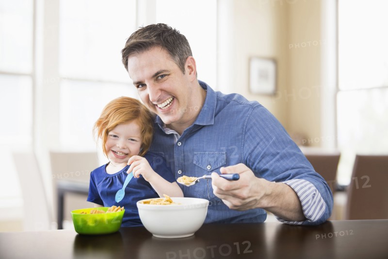 Caucasian father and daughter eating breakfast together