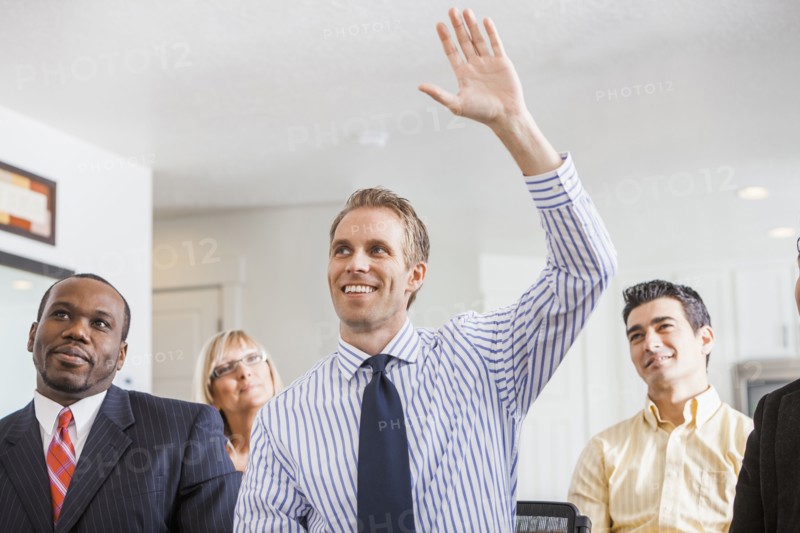 Businessman raising his hand in office