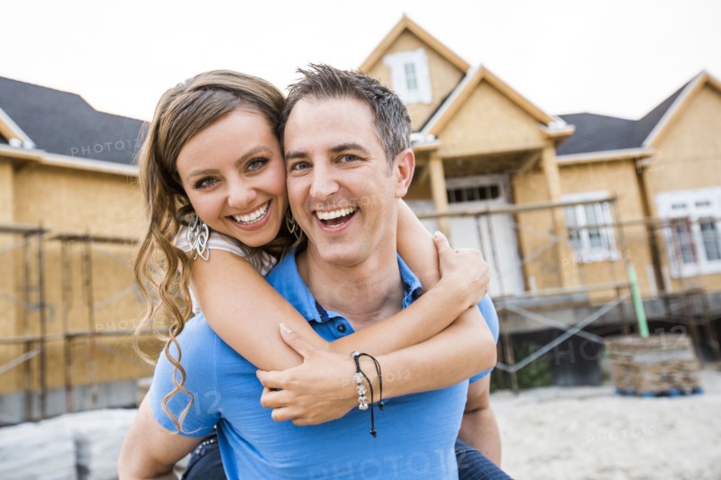 Caucasian couple hugging near house under construction