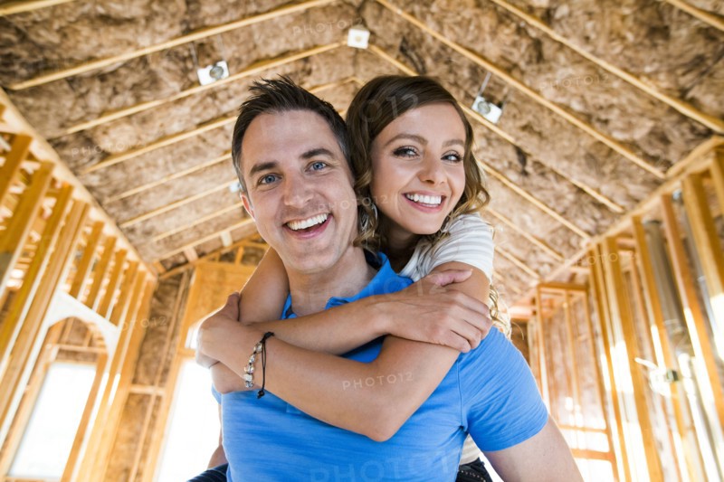 Caucasian couple hugging in house under construction
