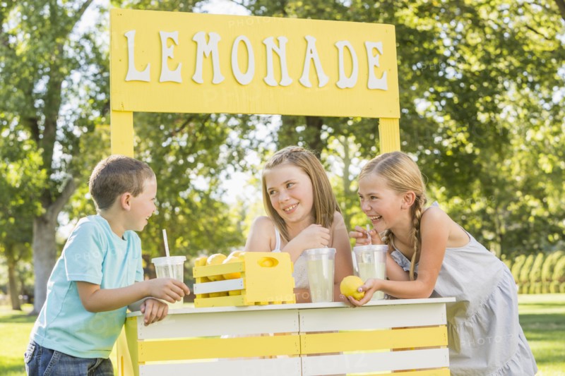 Caucasian children talking at lemonade stand