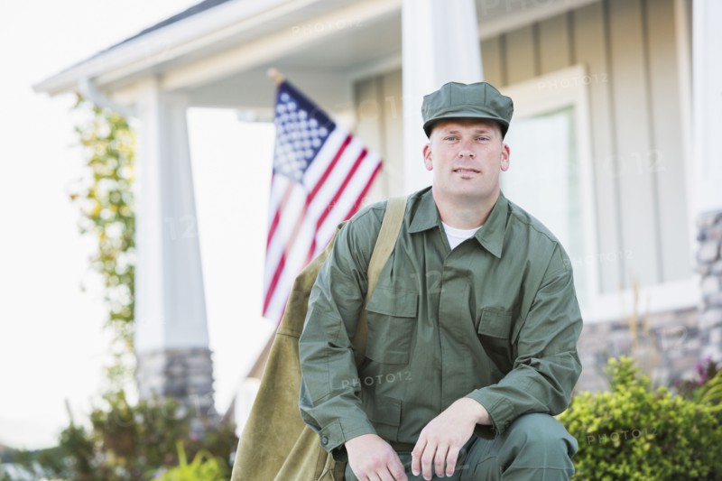 Caucasian soldier kneeling near house