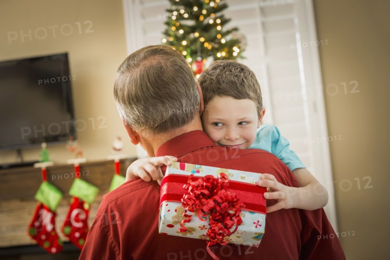 Caucasian grandson hugging grandfather with Christmas gift