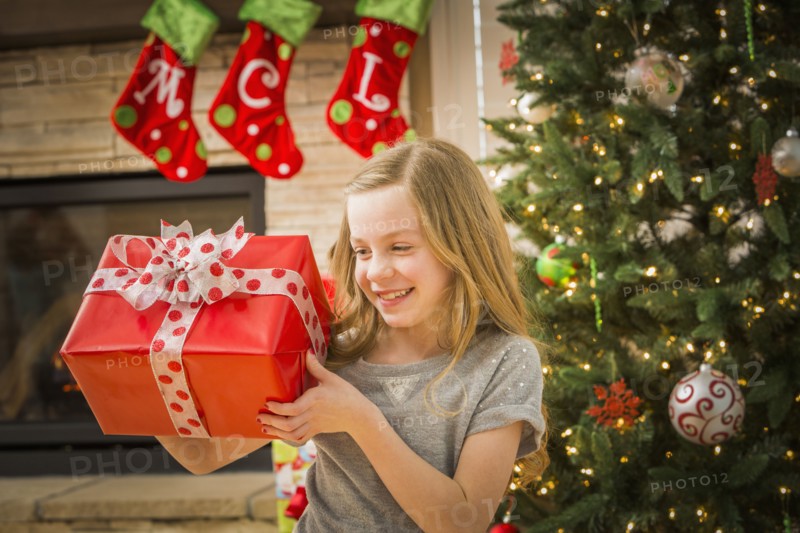 Caucasian girl examining Christmas gift