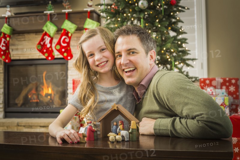 Caucasian father and daughter arranging nativity at Christmas