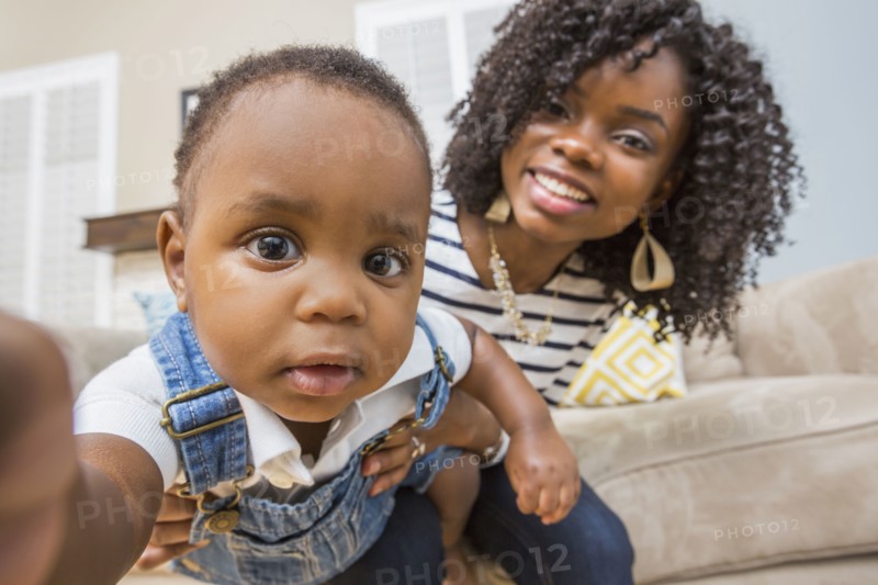 Close up of Black mother holding baby son on sofa