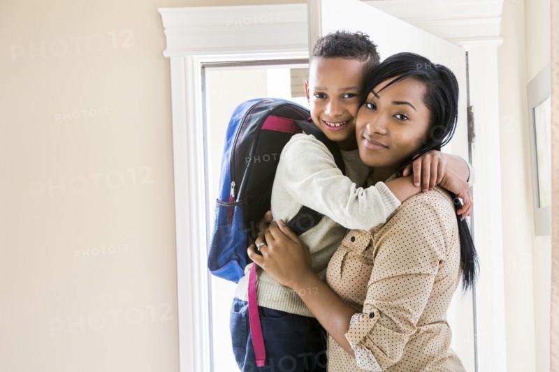 Mother and son hugging at door