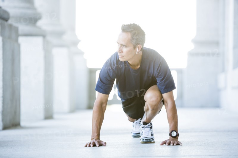 Mixed race man stretching outside courthouse