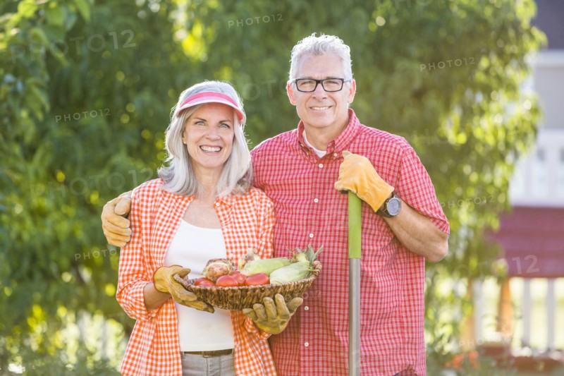 Caucasian couple gardening in backyard