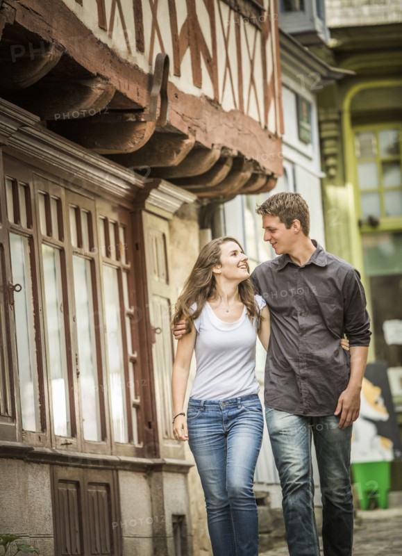 Caucasian couple walking in village