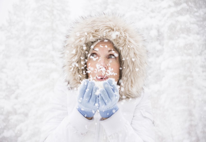 Caucasian woman playing in snow