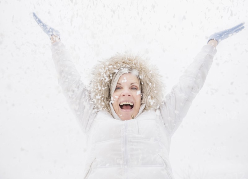Caucasian woman playing in snow