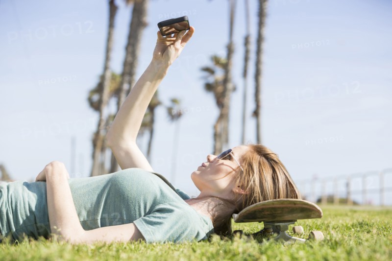 Caucasian woman using cell phone in park