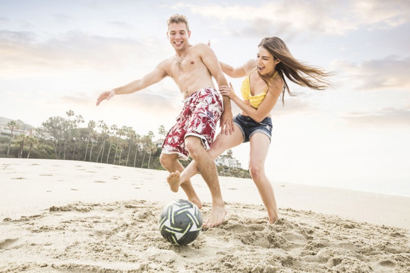 Caucasian couple playing on beach