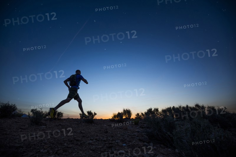 Silhouette of Caucasian teenage boy running at dawn