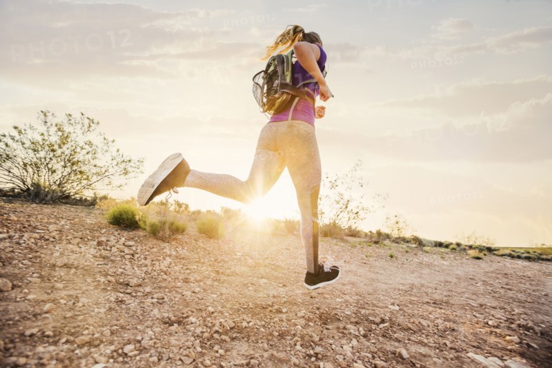 Caucasian woman running on remote hilltop