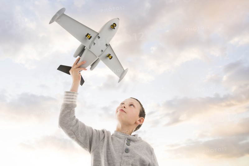 Caucasian boy flying toy airplane