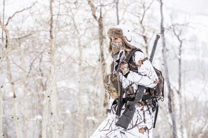 Caucasian woman hunting in forest wearing bandana