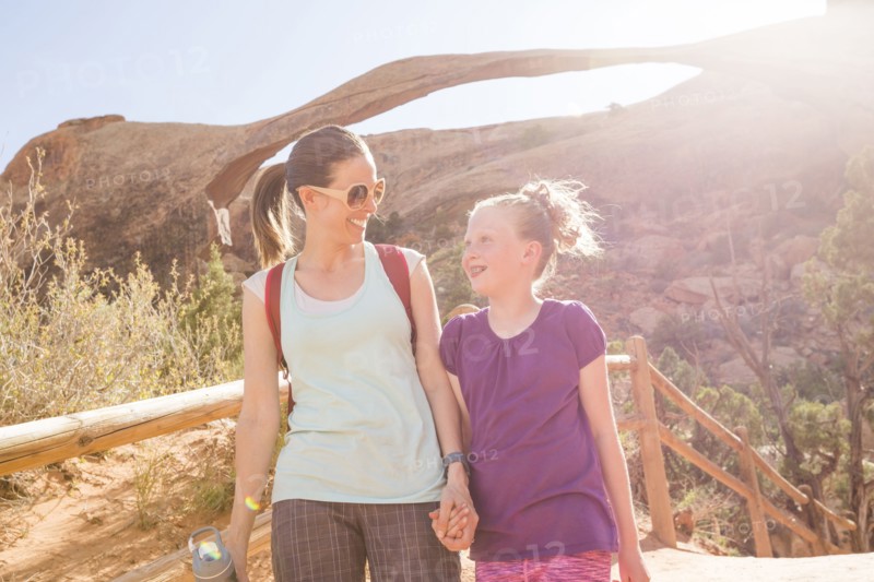 Caucasian mother and daughter holding hands and walking