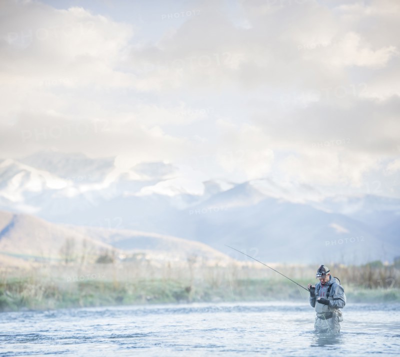 Caucasian man fly fishing in river