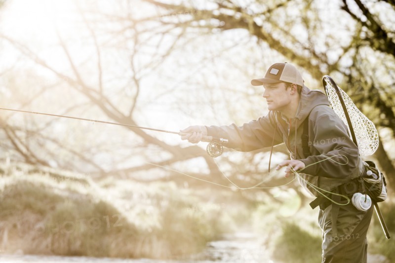 Caucasian man fly fishing in river