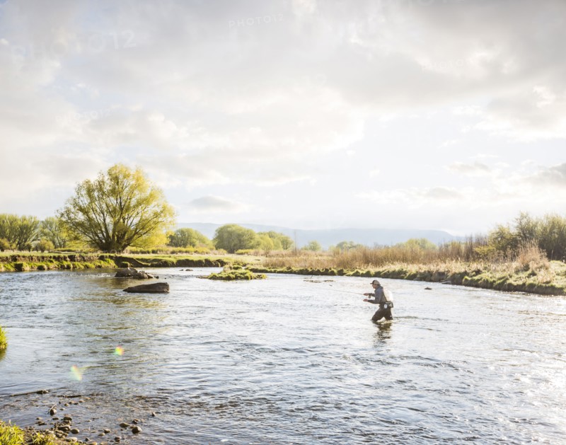 Caucasian man fly fishing in river