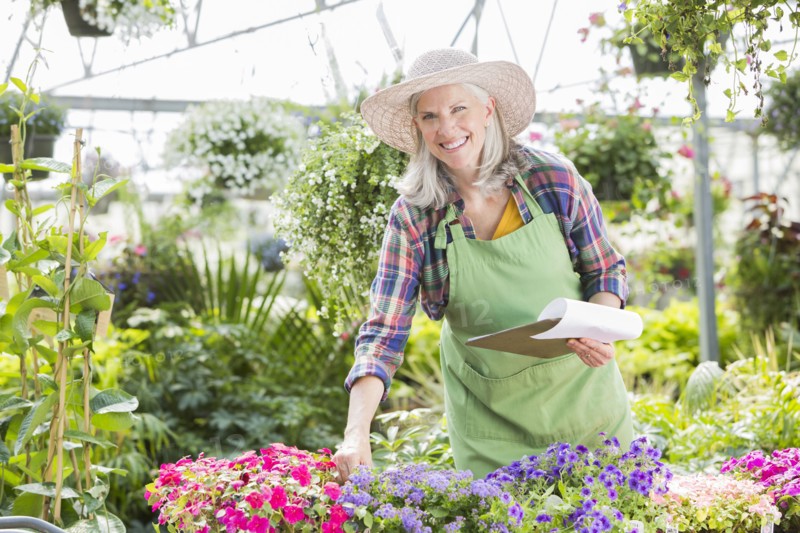 Caucasian woman holding clipboard in greenhouse