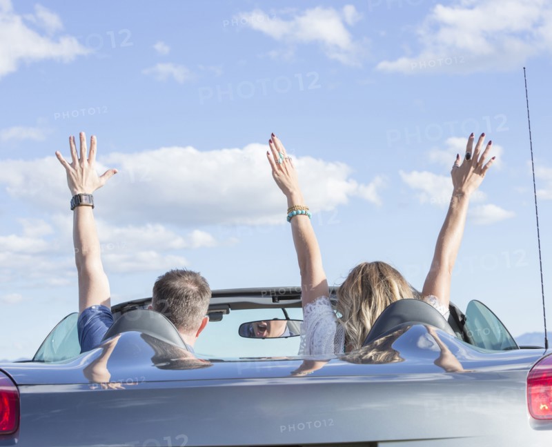 Caucasian couple driving in sports car