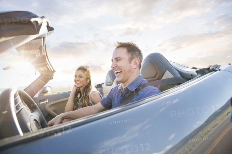 Caucasian couple driving in sports car