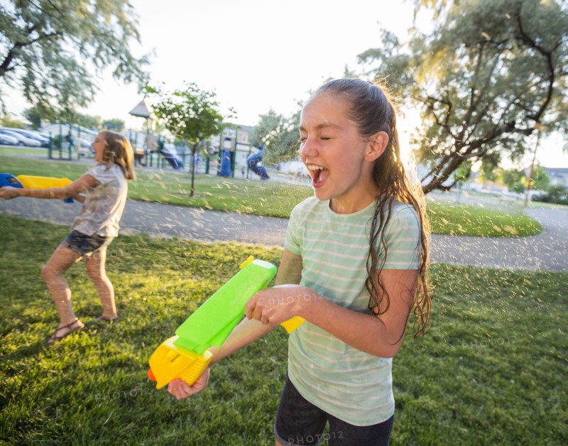 Wet Caucasian girls playing with squirt gun