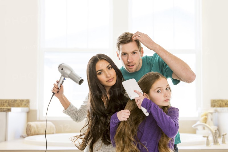 Family grooming hair in bathroom