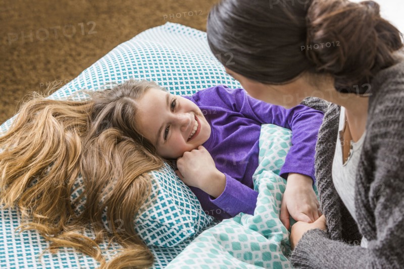 Mother comforting daughter at bedtime
