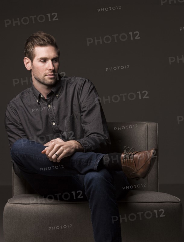 Serious Caucasian man sitting in armchair