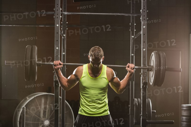 Caucasian man lifting barbell in gymnasium