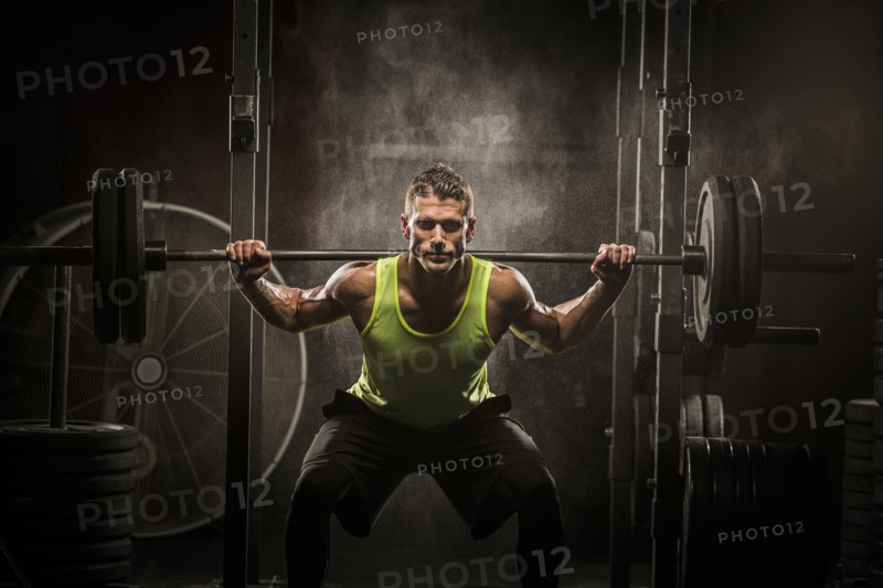 Caucasian man lifting barbell in gymnasium