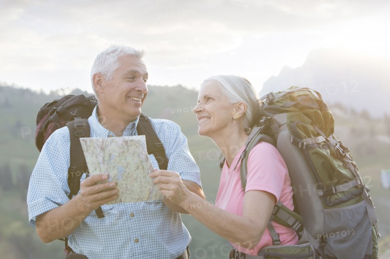 Caucasian couple hiking with map on mountain