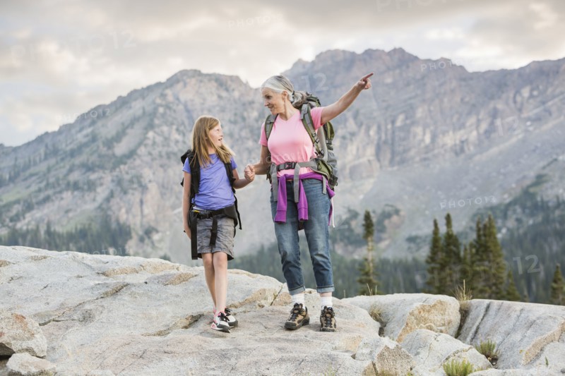 Caucasian grandmother and granddaughter hiking on mountain