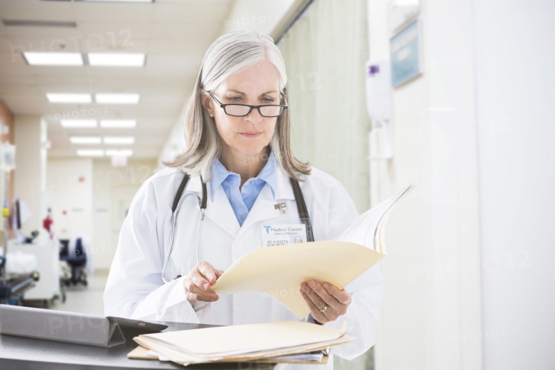 Caucasian doctor reading files in hospital